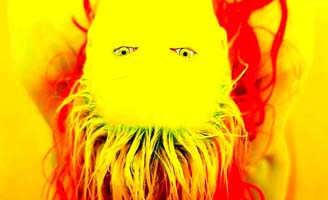 An abstract, highly saturated image of a person with long red hair, photographed upside down. Their face is bright yellow, with blue eyes and a streaky, almost beard-like effect on the chin area.